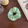 Green and yellow plaid scrunchie made of textured fabric on a wooden table - Colorful Green