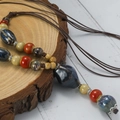 Ethnic style ceramic necklace with colorful beads and long braided rope on wooden stand - Multicolor