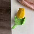 Nahaufnahme der Tulpen-Haarklammer mit gelben Blüten und kleinen Straßsteinen auf Blättern - Gelbe Tulpe Haarklammer