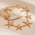 Detailed view of textured gold starfish pendant necklace with adjustable lobster clasp - Gold