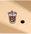Vista macro de un pin esmaltado de taza de café con cierre de mariposa negro para ropa - Café helado