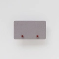 Detailed view of red gemstone stud earrings with silver four-prong setting - January: Red