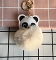 Nahaufnahme eines Panda-Schlüsselanhängers mit beigem Plüschball und goldenen Elementen - Gebrochenes Weiß