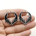 Gothic bat charms in hand showing size, black enamel with silver metal finish - Black Silver