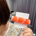 Macro detail of creative crab stick hair clip with realistic food texture on display card - Mutton Roll