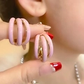 Dettaglio macro di orecchini a strati in smalto rosa con finitura in oro lucido per donne - Rosa
