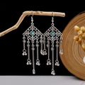 Macro view of Bohemian silver tassels and turquoise inlay on a wooden branch - E2870-6/Antique Silver Hollow Long Tassel Bell