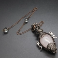 Detail of rose quartz teardrop pendant with copper floral frame and star design - Rose Quartz + Pendulum Chain