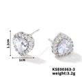 Macro detail of heart-shaped silver stud earrings with diamond halo and product dimensions - Silver Frame / White