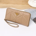 Dettaglio del portafoglio lungo beige in pelle con motivo a rombi e zip dorata - Albicocca