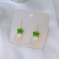 Close-up of tulip drop earrings with green bows and white flower buds on display card - Lily of the Valley Earrings