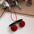 Detailed view of red velvet cherry charm with green leaves on a festive wooden tray - 50# Flocked Cherry Bow Necklace