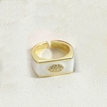 Detail eines quadratischen Goldrings mit weißem Emaille und Zirkonia-Teufelsauge - Weiß