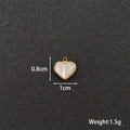 Macro detail of heart-shaped pearl pendant with gold metal edges and size measurements - Heart