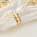 Detail of gold-plated rings with pink zircon on soft white silk with pearls - Two-Piece Set / Gold/Pink