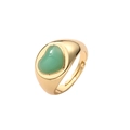 Gros plan sur une bague ajustable dorée avec une pierre verte en forme de cœur - Ouvert Réglable / Vert