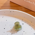 Mini green translucent hair claw clip for bangs and side hair styling on a decorative plate - Greenish Brown