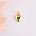 Dettaglio ravvicinato di un ciondolo a cuore dorato con uno zircone verde scintillante - Zircone Verde