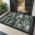 Green cactus print entry mat with black rubber border on a wooden floor - Thorny Shadow Sand Forest