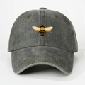 Close-up of embroidered bee pattern on washed dark grey cotton baseball cap with vent holes - One Size / Army Green