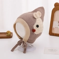Detailed close-up of a baby knitted hat with cute rabbit jacquard and ear protection ties - 48-50cm / Brown