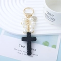 Portachiavi con perle bianche e ciondolo a croce nera con strass luccicanti - Nero