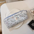 Dettaglio dell'astuccio in cotone blu con stampe di fiori e anatre e chiusura lampo - Oca Bianca Foglia Verde