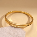 Detailansicht des 18k vergoldeten Armreifs mit Zirkonia und Kugelverschluss auf Stein - Gold (18K Vergoldet)