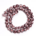 Macro shot of dark purple Millefiori glass beads with red and white floral patterns - Purple Red Flower