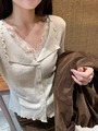 Gros plan du cardigan en maille côtelée beige avec dentelle blanche et col à volants - S / Blanc