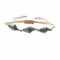 Detail eines geflochtenen Seilarmbands mit blauen Keramikmuscheln und Perlenakzenten - Cyan