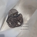 Pince à cheveux gris fumé translucide avec ressort en métal sur tissu blanc léger - Gris