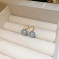Detaillierte Nahaufnahme grauer Perlen an 18K Goldhaken in einer Schmuckschatulle - 10mm Graue Perle Goldener Ohrhaken