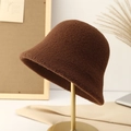 Detailed texture of dark brown plush wool bucket hat on a gold display stand - Coffee