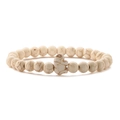 Macro detail of white turquoise beaded bracelet featuring a central elephant charm pendant - Beige White Turquoise