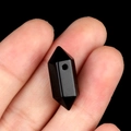 Polished black obsidian double pointed hexagonal prism pendant bead held in hand - Obsidian