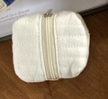 White quilted cable organizer bag with textured fabric and top zipper closure - White