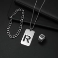 Detail eines silbernen Schmucksets aus Titanstahl mit R-Buchstaben-Kette, Armband und Ring - Set R