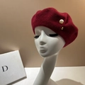 Detailed close-up of dark red wool beret featuring a large pearl and golden metal rivet - M (56-58cm) / Burgundy