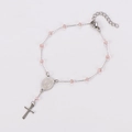 Detailed view of silver cross pendant and pink beads on a religious rosary bracelet - Pink