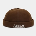 Close-up of white NEEDS embroidery on a dark brown cotton canvas docker hat - Adjustable / Coffee