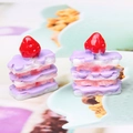 Macro detail of two miniature resin strawberry cakes for DIY jewelry and crafts - Pink Purple + White