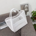 Close-up of white hollow jelly tote bag with diamond pattern on a stylish sofa - Small White