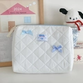 Close-up of quilted cosmetic bag with blue ribbon bows and soft fabric texture - White Hand Pouch