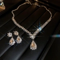 Macro view of teardrop rhinestone pendant necklace and earrings with starburst lighting - Silver Rhinestone Teardrop Style