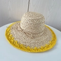 Detalle de sombrero de rafia con ala ancha, borde amarillo y lazo trenzado - Amarillo