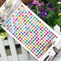 Close-up of multicolor 3mm acrylic rhinestone stickers in a clear plastic retail bag - 6mm / Colorful