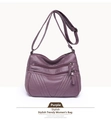 Macro shot of purple washed PU leather texture with multiple zipper pockets on a crossbody bag - Purple