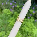Detailed macro of a gold-plated criss-cross ring set with sparkling cubic zirconia stones - X-shape Double Layer Cross Style