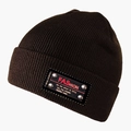 Gros plan d'un bonnet en maille marron foncé avec écusson noir, rivets argentés et texte rouge - L (58-60cm) / café